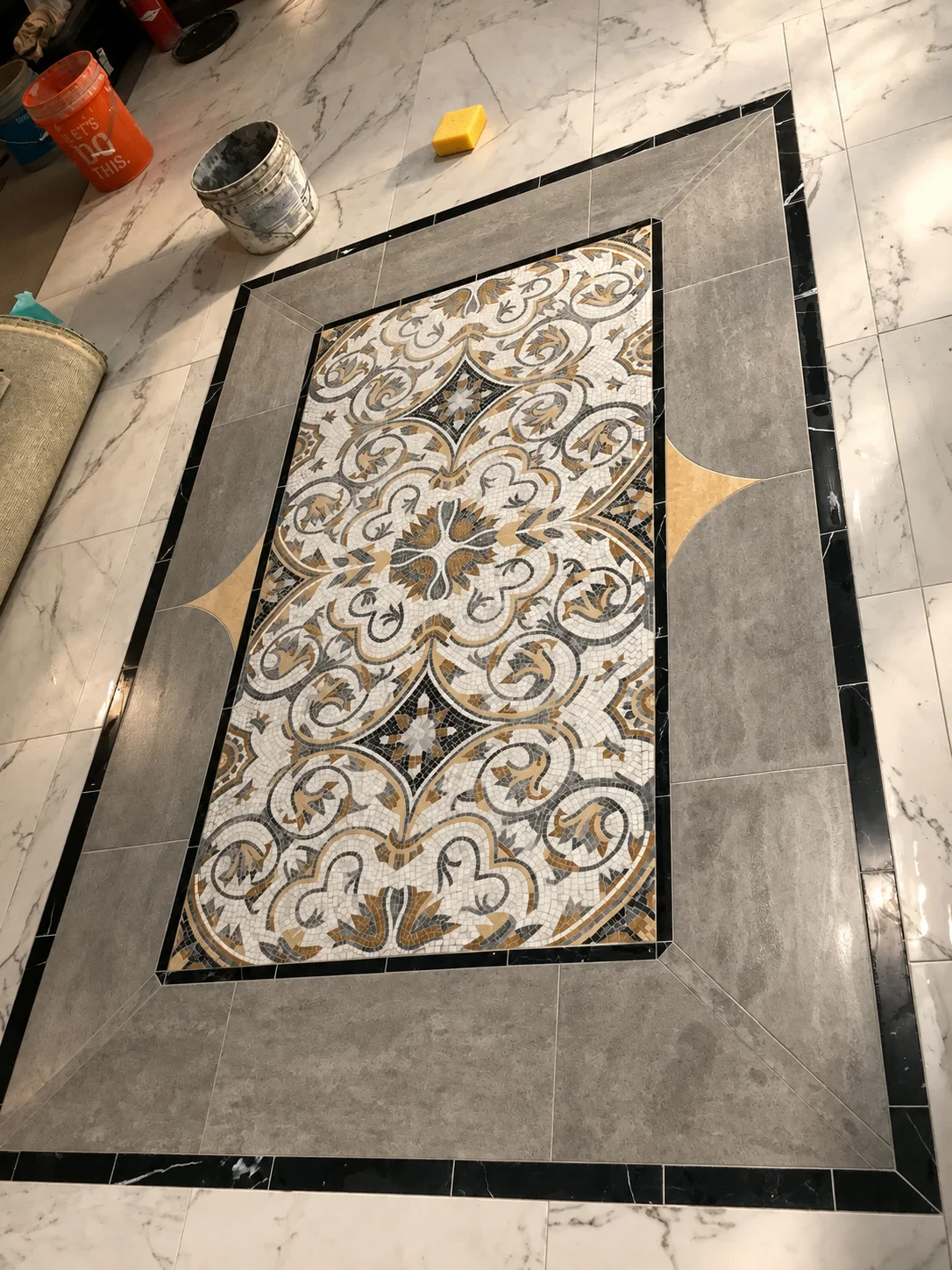 Inlaid decorative tile medallion rug in marble flooring