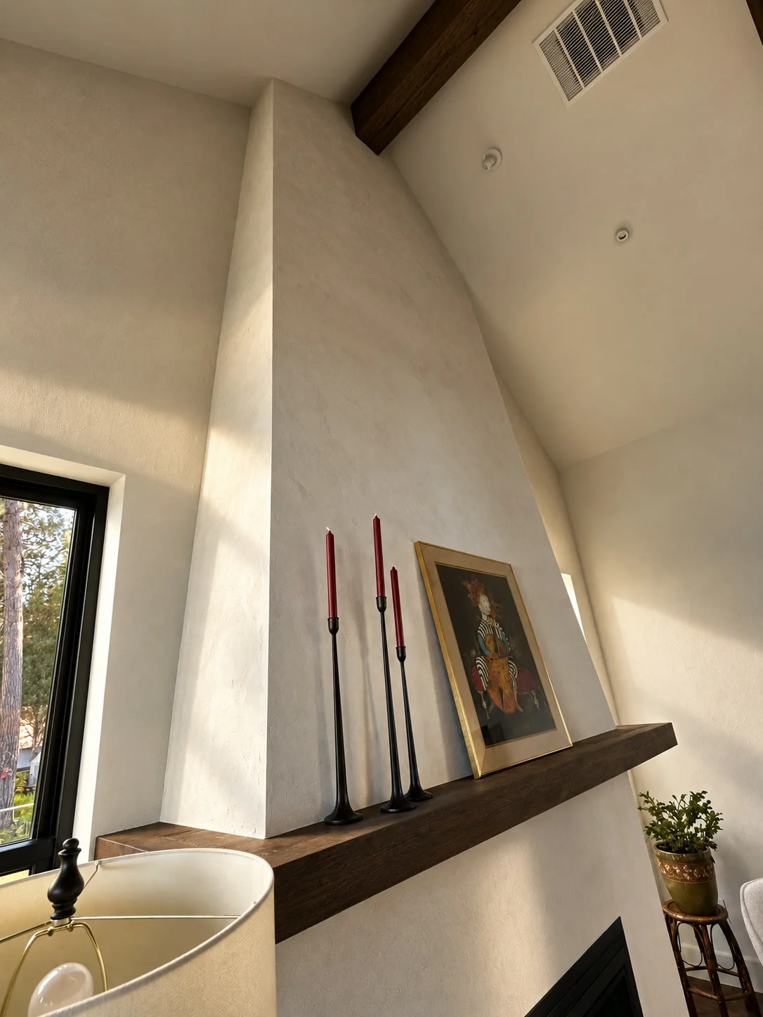 Plaster fireplace chimney with timber mantle shelf and ambient lighting