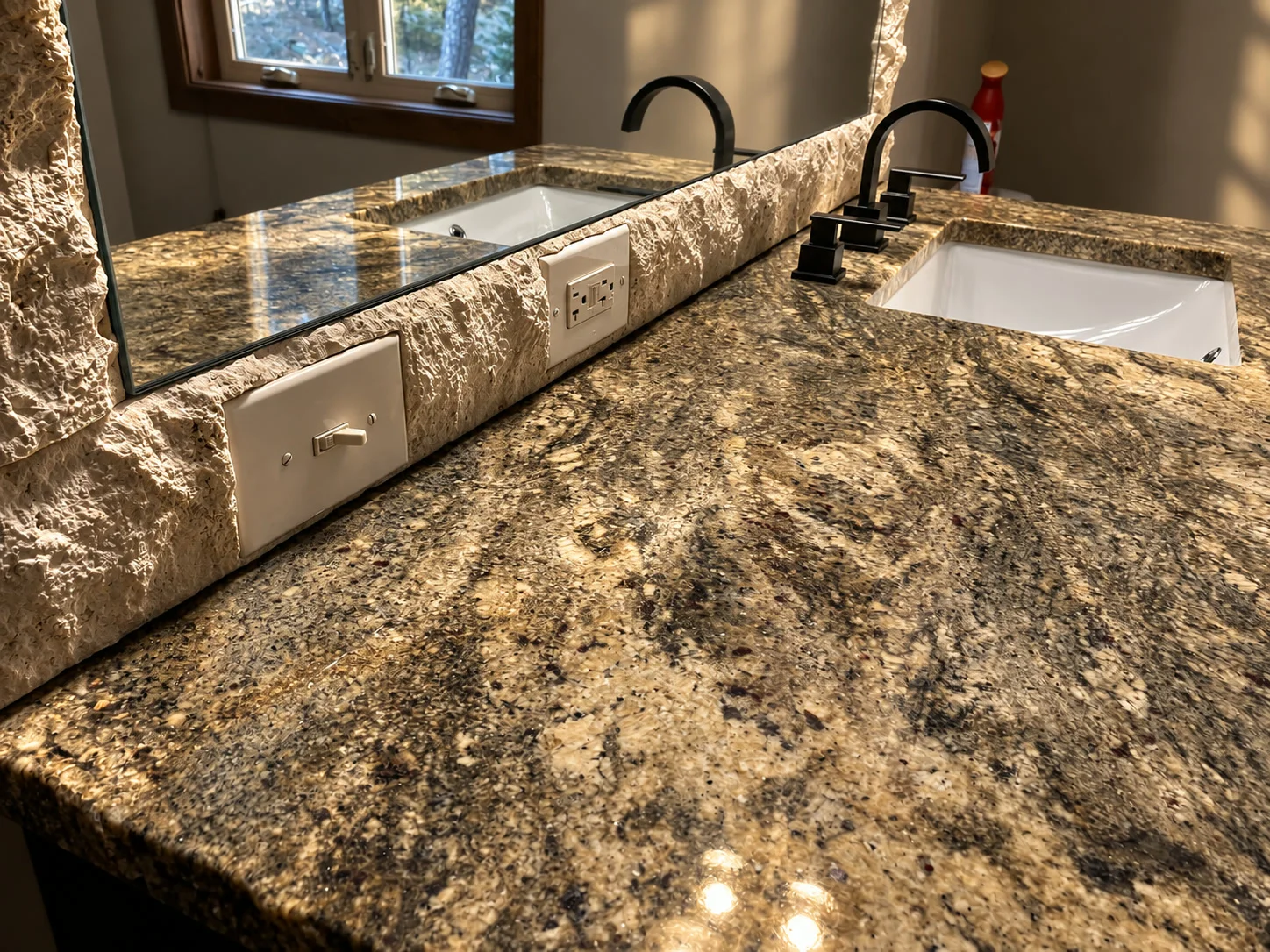 Chiseled rock-face granite bathroom vanity countertop with undermount sinks