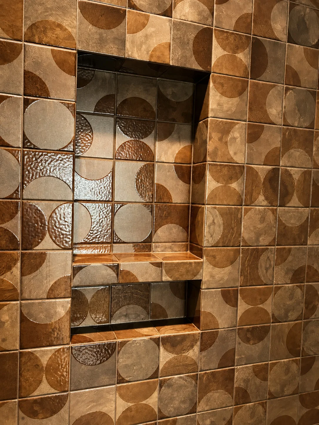 Geometric patterned ceramic tile shower wall with recessed storage niche