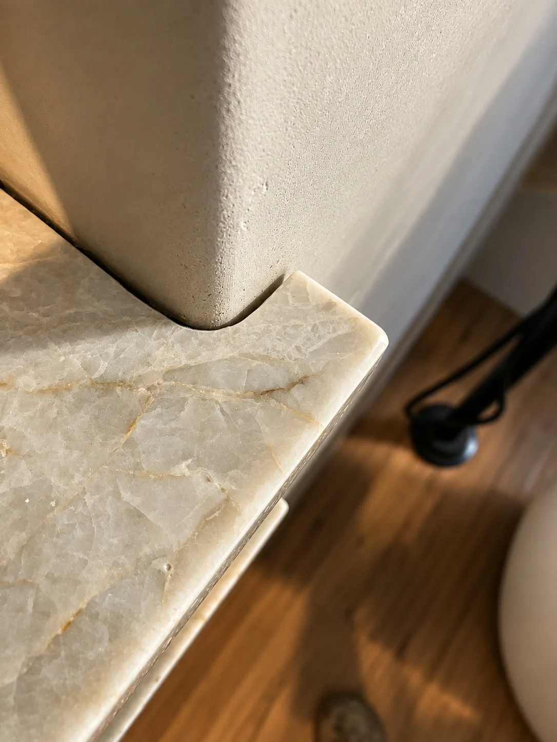 Custom marble countertop corner precisely notched and scribed to plaster wall