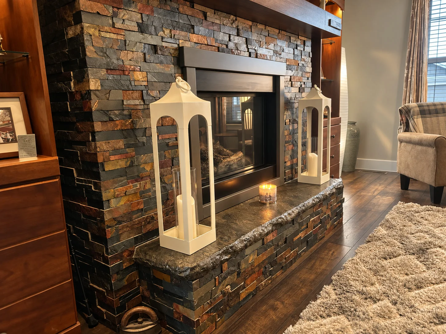Stacked stone fireplace with raised hearth and custom built-in cabinetry